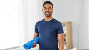 Smiling Male Model Holding Yoga Mat