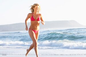Female in red bikini running on beach | Westfield Plastic Surgery Center Female in red bikini running on beach