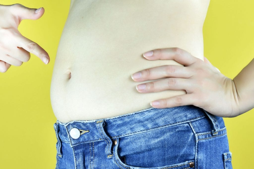 Hand Pointing to Pudgy Belly in Jeans | Westfield Plastic Surgery Center Hand Pointing to Pudgy Belly in Jeans